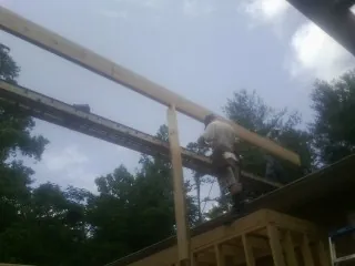 Carpenter setting a ridge beam over a new addition frame — Ice Dam Removal by Roofing Brothers in Walnut Bottom