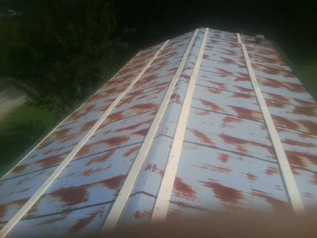 Rusted metal roof panels with new wood purlins before replacement — Storm Damage Roof Repair in Walnut Bottom by Roofing Brothers